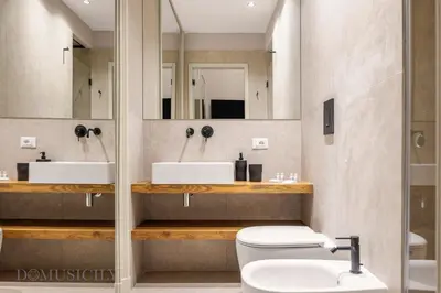 a bathroom with two sinks and a toilet and a mirror at Palazzo Cavarretta - Le Stanze dei Baroni in Palermo