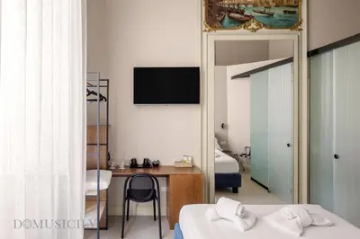 a bedroom with two beds and a desk and a mirror at Palazzo Cavarretta - Le Stanze dei Baroni in Palermo
