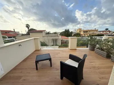 a balcony with a chair and a table at Magnolia Home in Terrasini