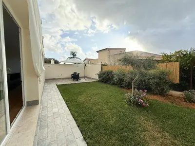 a backyard with a lawn and a fence at Magnolia Home in Terrasini