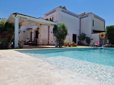 a swimming pool in front of a house at Villa indipendente con piscina in Terrasini
