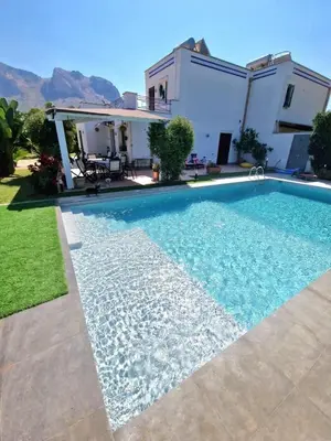 a swimming pool in front of a house at Villa indipendente con piscina in Terrasini