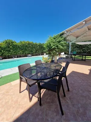 a patio with a table and chairs and a pool at Villa indipendente con piscina in Terrasini