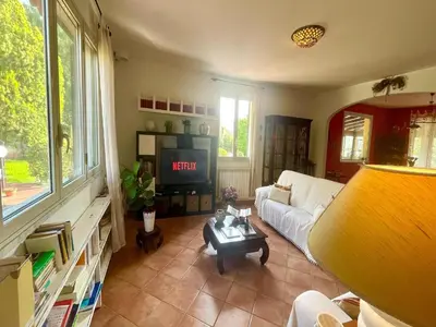 a living room with a white couch and a tv at Villa in Palermo near the Sea in Altofonte