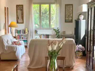 a living room with a couch and a vase of flowers at Villa in Palermo near the Sea in Altofonte