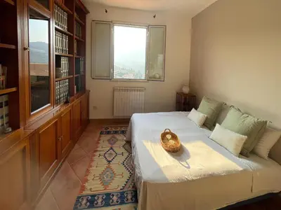 a bedroom with a large bed and a window at Villa in Palermo near the Sea in Altofonte