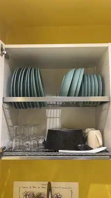 a shelf with plates and bowls in a refrigerator at Sunny Apartament in Palermo