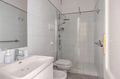 a white bathroom with a toilet and a sink at Sunny Apartament in Palermo