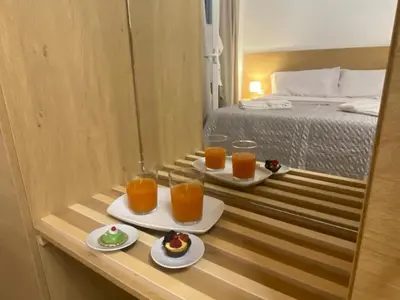 a hotel room with two glasses of orange juice and desserts at Le Gemme di Ballarò in Palermo