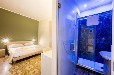 a bathroom with a shower and a bed in a room at Ramona House in Palermo
