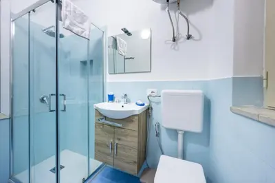 a bathroom with a toilet and a sink and a shower at Anita House in Palermo