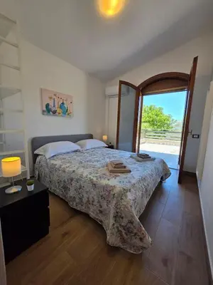 a bedroom with a bed and a large window at Villa Giacoma hot tub and garden in Mandra Capreria
