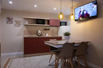 a kitchen with a table and chairs and a tv at Casa SMART in Palermo