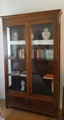 a wooden book shelf with books in it at una casa tranquilla in Palermo