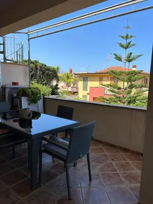 a patio with a table and chairs on a balcony at Villa Irene in Isola delle Femmine