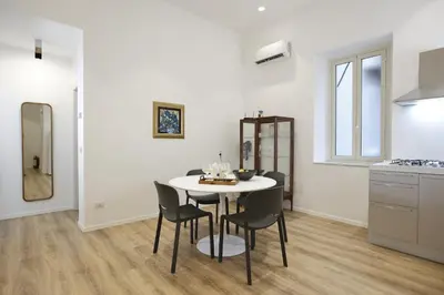 a kitchen and dining room with a table and chairs at Devalù Politeama - Elegante appartamento al Politeama in Palermo