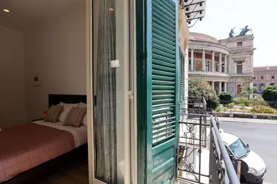 a room with a bed and a balcony with a window at Devalù Politeama - Elegante appartamento al Politeama in Palermo