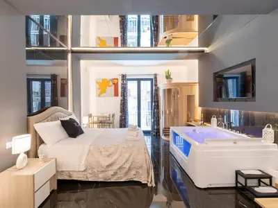 a bedroom with a large bed and a bath tub at Cupido Apartment in Palermo