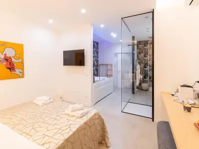a bath tub in a bedroom with a bed at Cupido Apartment in Palermo