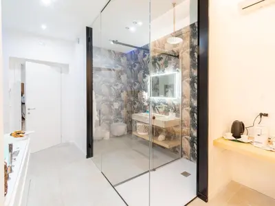 a glass shower in a bathroom with a sink at Cupido Apartment in Palermo