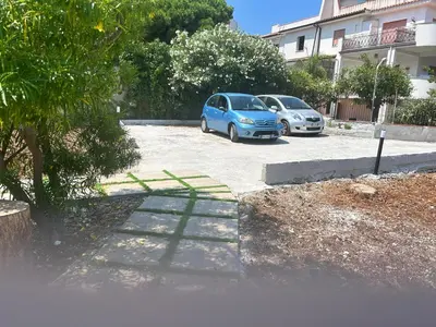 two cars parked in a parking lot next to a building at Via dei mirtilli in Carini