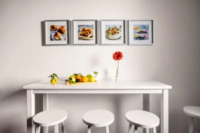 a white table with four pictures on the wall at La Casa del Genio in Palermo