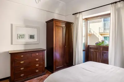 a bedroom with a bed and a dresser and a window at La Casa del Genio in Palermo