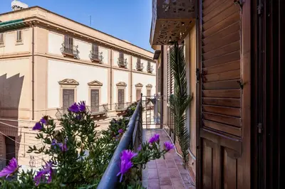 a view of a building with purple flowers at La Casa del Genio in Palermo