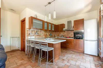 a kitchen with wooden cabinets and a white refrigerator at Antonio Family House a Mondello by Wonderful Italy in Palermo