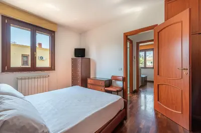 a bedroom with a bed and a desk and a window at Antonio Family House a Mondello by Wonderful Italy in Palermo