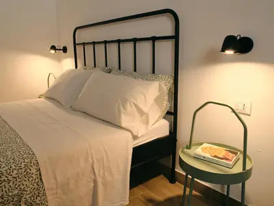a bedroom with a bed and a table with a book at La casa di giù in Palermo