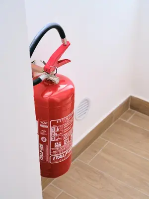 a red fire hydrant is standing next to a wall at La casa di giù in Palermo