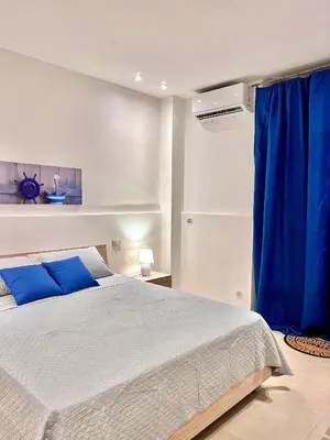 a bedroom with a bed and a blue curtain at Moonlight Rooms in Termini Imerese