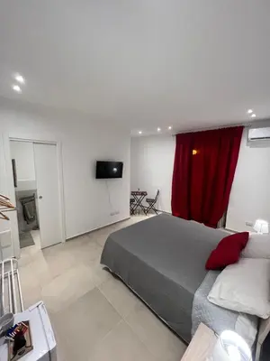 a bedroom with a bed and a red curtain at Moonlight Rooms in Termini Imerese