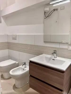a bathroom with a sink and a toilet and a mirror at Moonlight Rooms in Termini Imerese