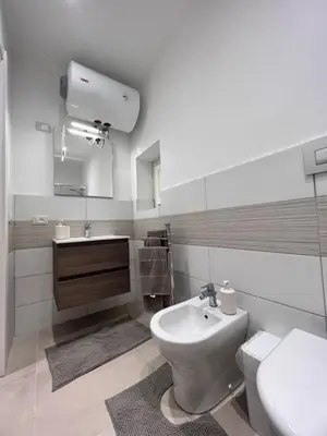 a white bathroom with a sink and a toilet at Moonlight Rooms in Termini Imerese