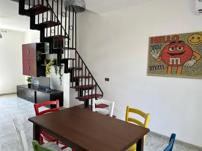 a dining room with a table and a spiral staircase at MondHello a 2 passi dal mare in Palermo