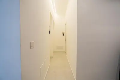a hallway with white walls and a long corridor at Ricci & Capricci Exclusive Room in Aspra