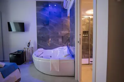 a large bath tub in a bathroom with a tv at Ricci & Capricci Exclusive Room in Aspra