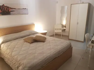 a bedroom with a large bed with a wooden headboard at Buonaluna B&B in Palermo