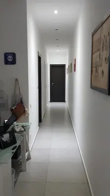 a hallway with white walls and a black door at Buonaluna B&B in Palermo