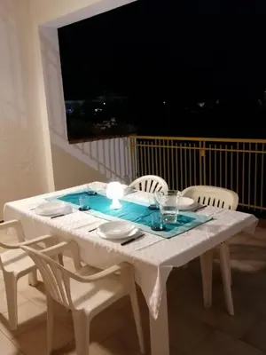 a white table with white chairs and a television at Alta Marea Mondello - Palermo in Palermo