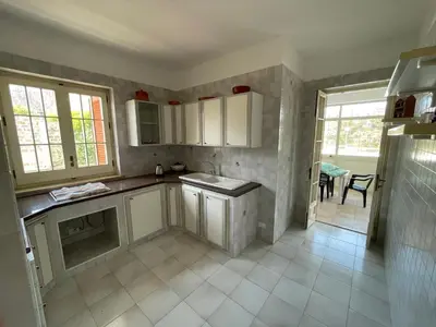 a kitchen with white cabinets and a sink at Alta Marea Mondello - Palermo in Palermo