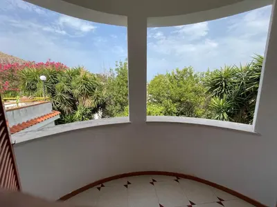 a large window in a room with a view of trees at Alta Marea Mondello - Palermo in Palermo