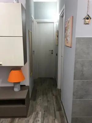 a hallway with a door and a table and a lamp at Villaggio 101 Pini in Buonfornello