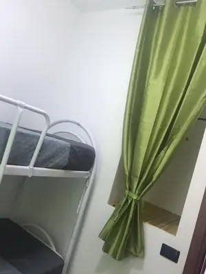 a green curtain in a room with a bunk bed at Villaggio 101 Pini in Buonfornello