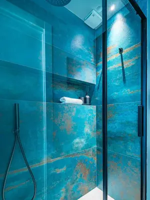 a bathroom with a shower with blue walls at Meschita Sette in Palermo