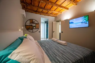 a bedroom with a bed with a tv on the wall at Meschita Sette in Palermo