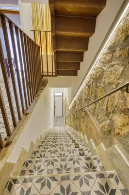 a hallway with a tile floor and wooden stairs at VFH La Rada Apartments in Santa Flavia