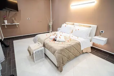 a bedroom with a bed with white sheets and pillows at Suite del Corso in Ficarazzi